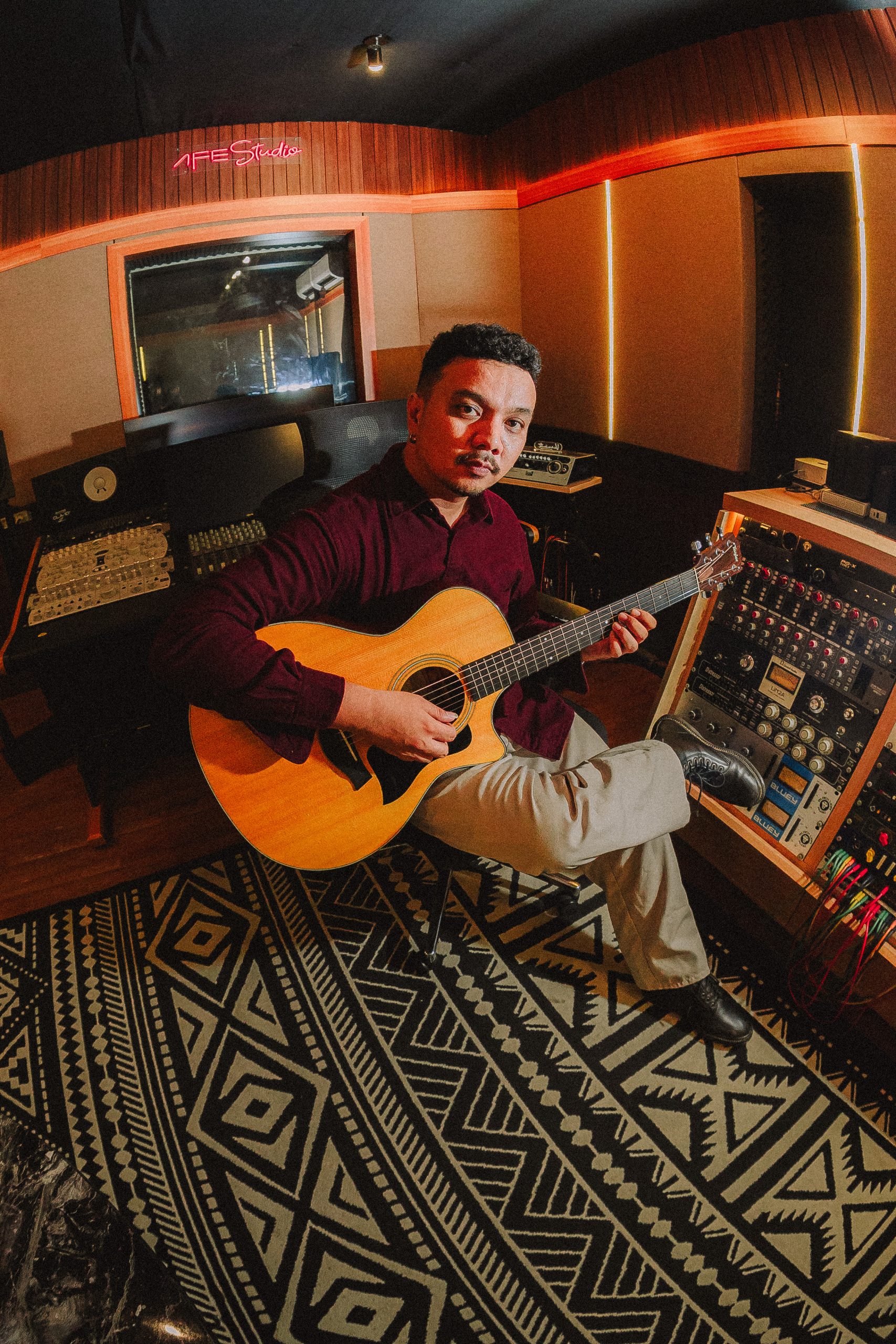 Kevin Pangestv in studio with acoustic guitar