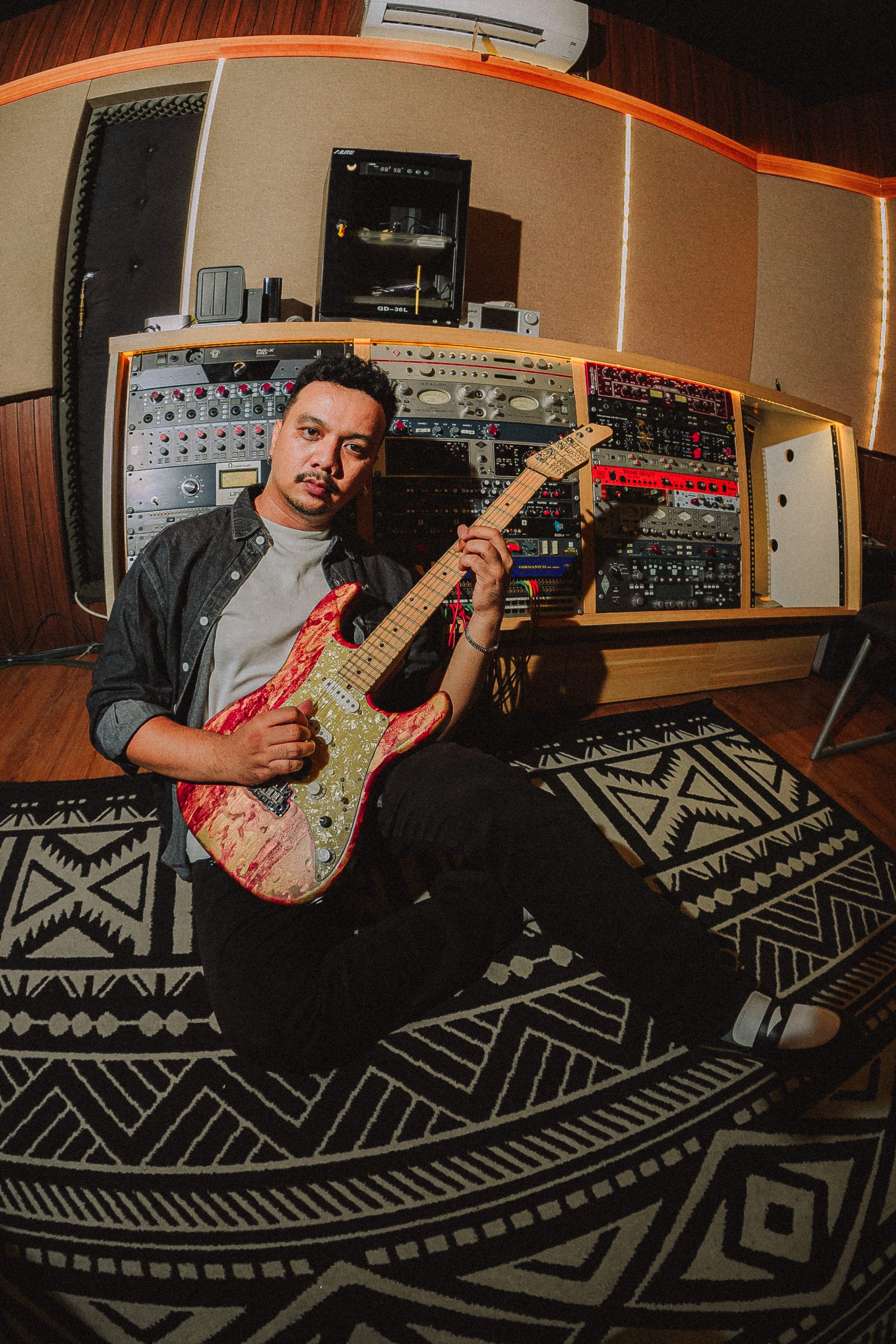 Kevin Pangestv with electric guitar in studio
